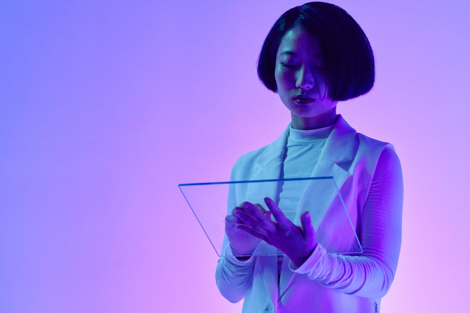 Woman interacts with a transparent digital screen in vibrant studio lighting